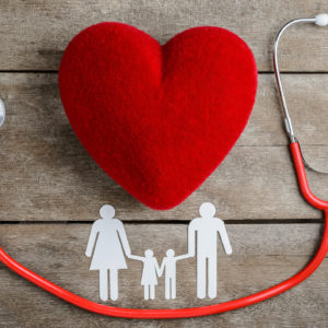 Red heart, stethoscope and paper chain family on wooden table, Health Insurance Concepts